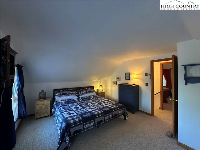 a bedroom with a bed and a flat tv screen on dresser