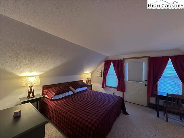 a bedroom with a bed next to a window