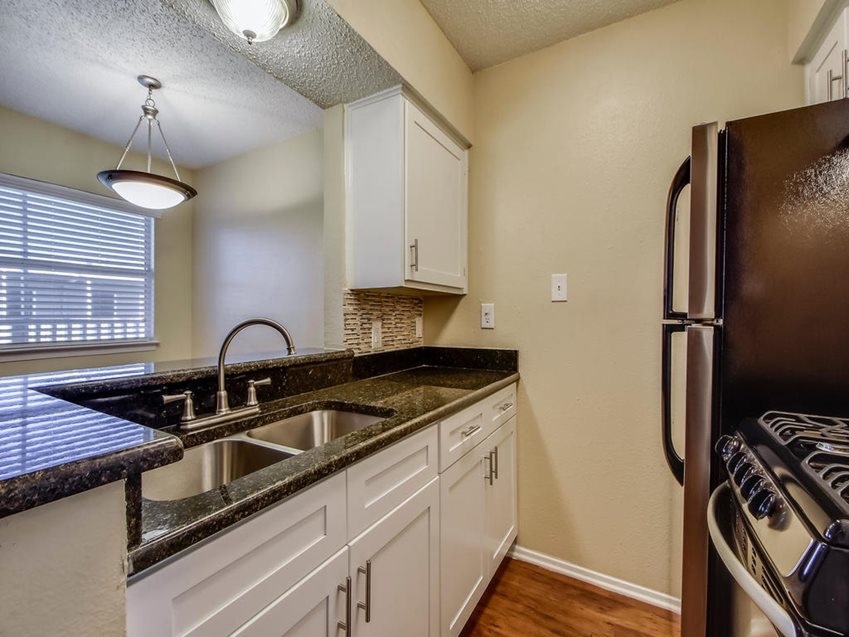 2401 Manor Road, Unit 119 Austin, TX 78722 - Photo 1 of 5 a kitchen with stainless steel appliances granite countertop a sink stove and refrigerator