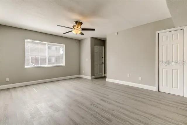 300 6th Street North, Unit W2 Safety Harbor, FL 34695 - Photo 14 of 22 an empty room with wooden floor chandelier fan and windows