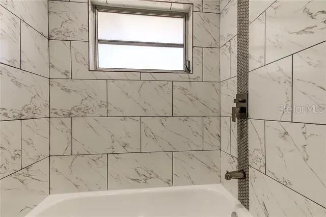 300 6th Street North, Unit W2 Safety Harbor, FL 34695 - Photo 18 of 22 a bathroom with a bathtub and window