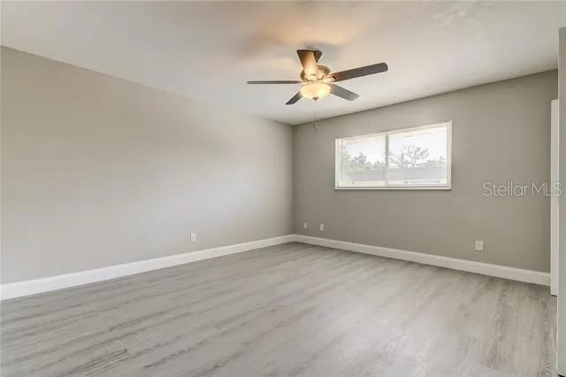 300 6th Street North, Unit W2 Safety Harbor, FL 34695 - Photo 20 of 22 an empty room with wooden floor fan and windows