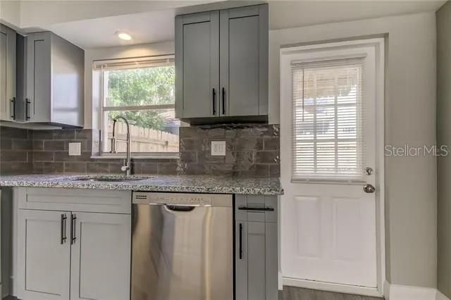 300 6th Street North, Unit W2 Safety Harbor, FL 34695 - Photo 7 of 22 a kitchen with granite countertop cabinets stainless steel appliances a sink and a window