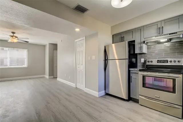 300 6th Street North, Unit W2 Safety Harbor, FL 34695 - Photo 9 of 22 a kitchen with stainless steel appliances a refrigerator and a stove top oven