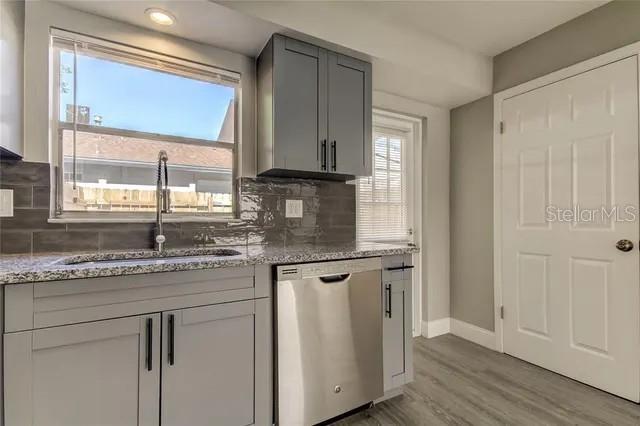 300 6th Street North, Unit W2 Safety Harbor, FL 34695 - Photo 10 of 22 a kitchen with granite countertop a sink and a window