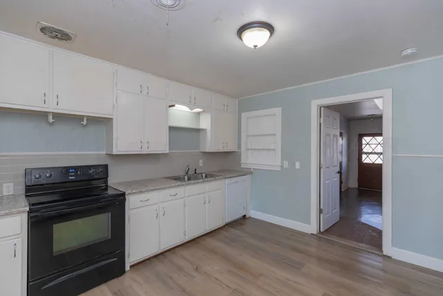 a kitchen with granite countertop a stove and a sink