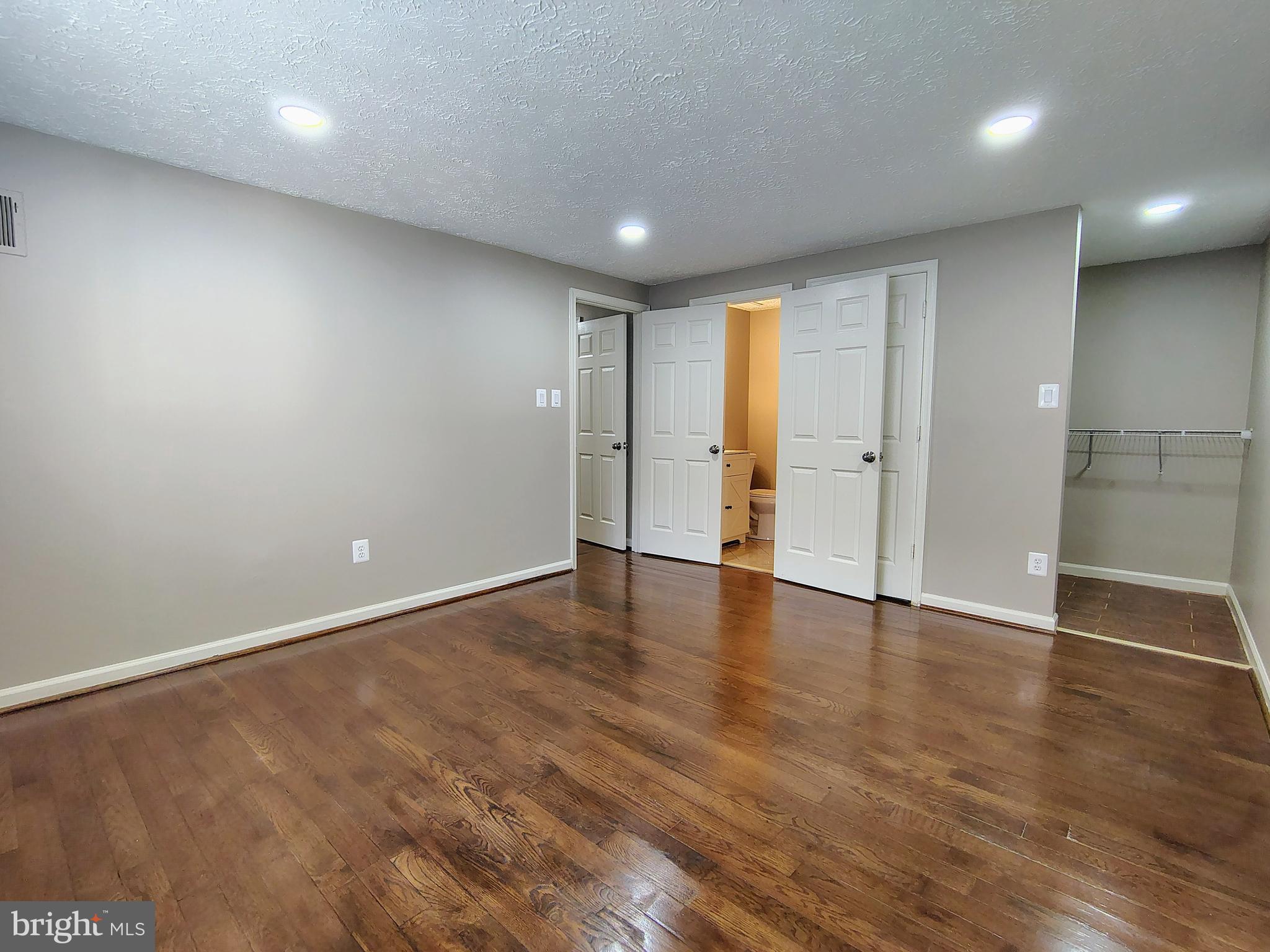 12407 Hickory Tree Way, Unit 524 Germantown, MD 20874 - Photo 17 of 21 an empty room with wooden floor and windows