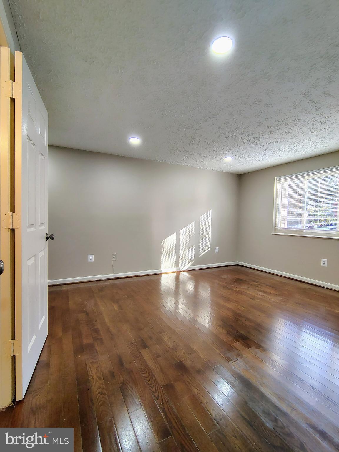 12407 Hickory Tree Way, Unit 524 Germantown, MD 20874 - Photo 18 of 21 an empty room with wooden floor and windows