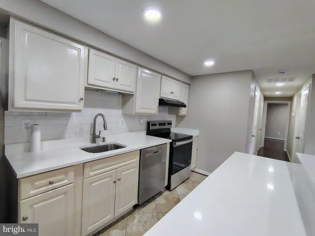 a kitchen with granite countertop white cabinets and white appliances