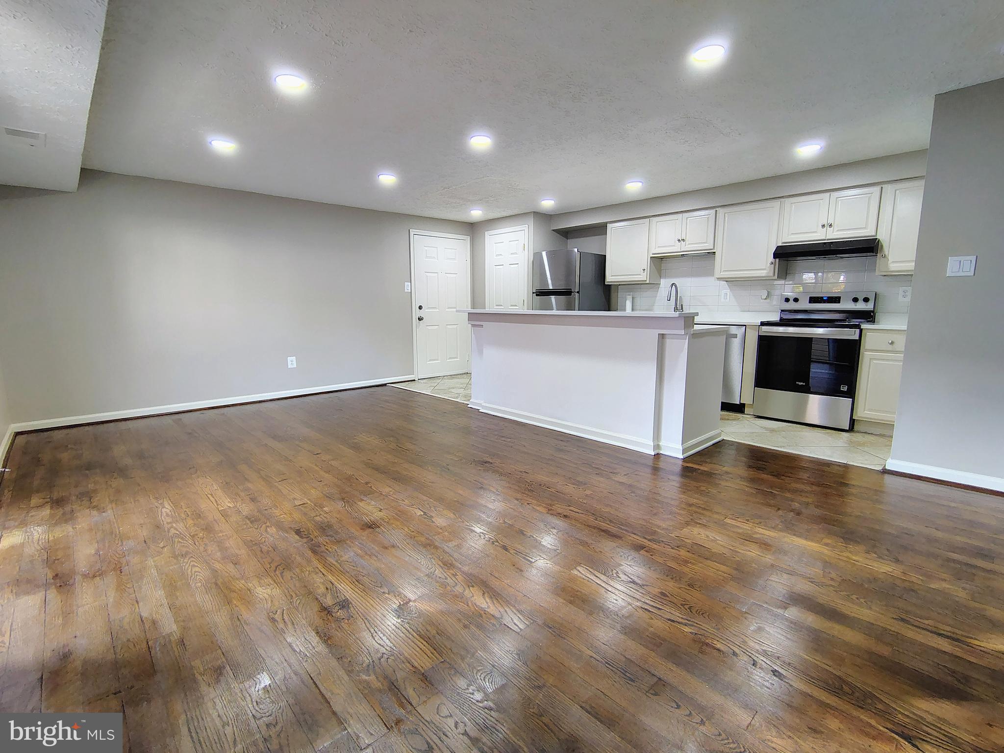 12407 Hickory Tree Way, Unit 524 Germantown, MD 20874 - Photo 7 of 21 a large kitchen with stainless steel appliances kitchen island a large counter top and a stove top oven