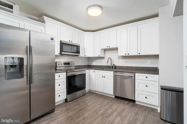 a kitchen with stainless steel appliances a refrigerator sink and microwave