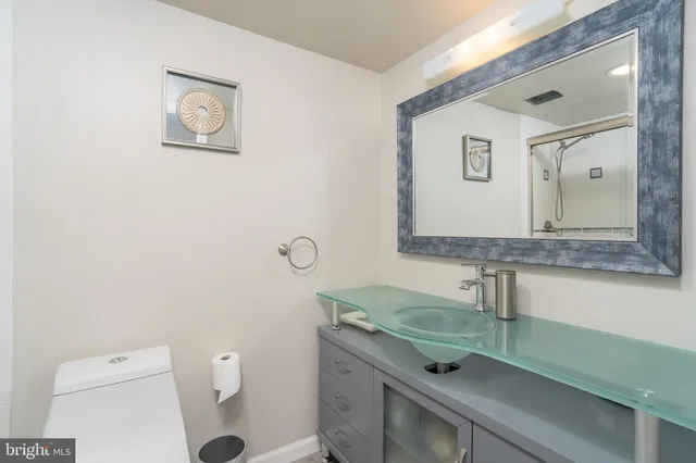 a bathroom with a granite countertop toilet sink and mirror