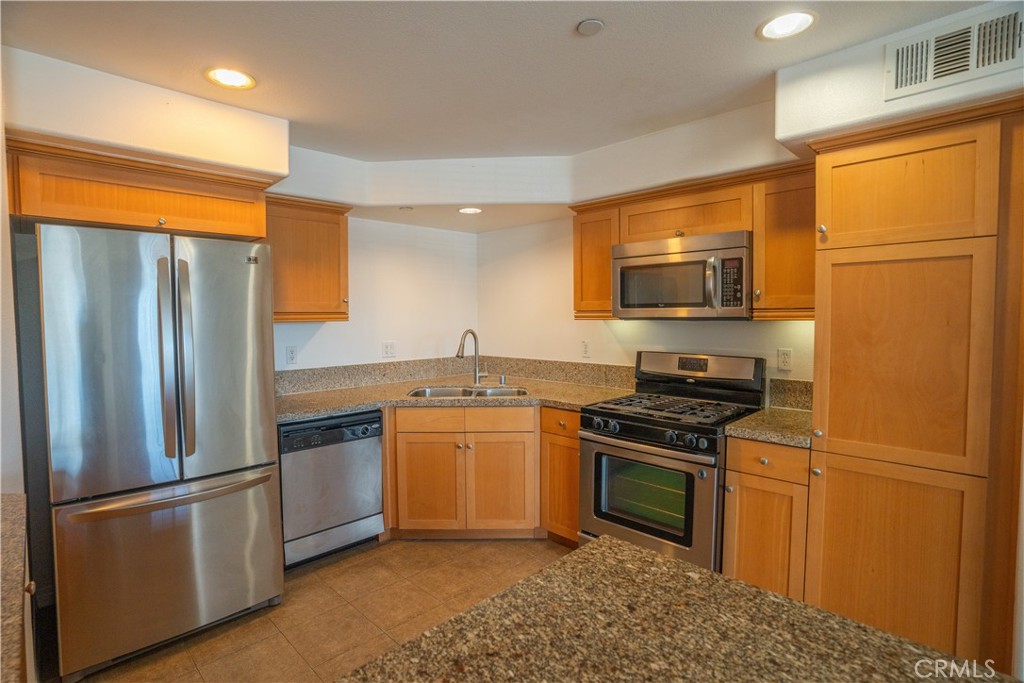 1401 Lomita Boulevard, Unit 302 Harbor City, CA 90710 - Photo 7 of 29 a kitchen with stainless steel appliances granite countertop a refrigerator stove top oven and sink
