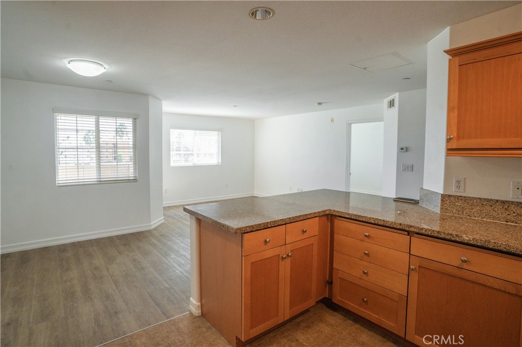 1401 Lomita Boulevard, Unit 302 Harbor City, CA 90710 - Photo 9 of 29 a kitchen with granite countertop cabinets a sink and dishwasher