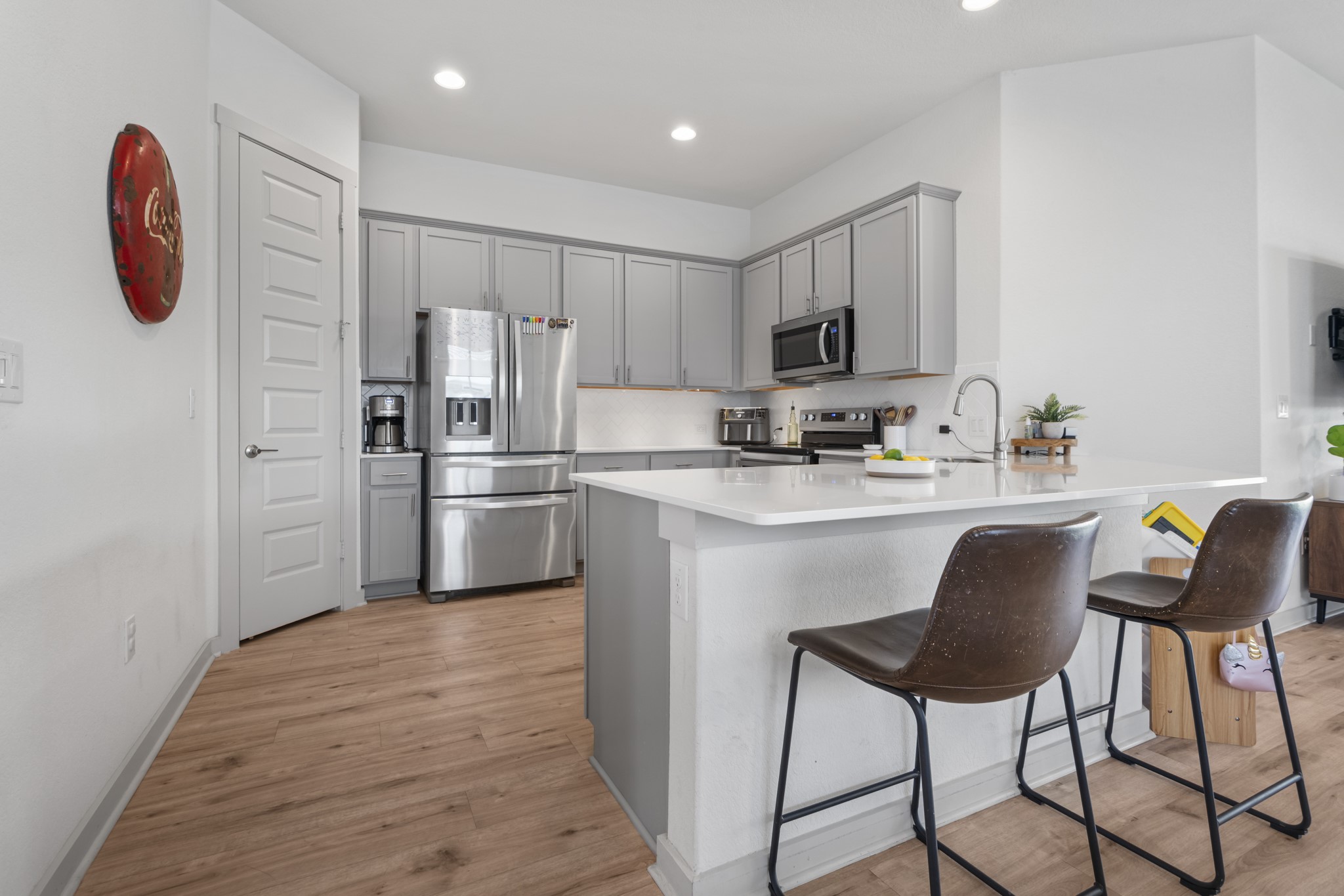 620 Peace Pipe Way Georgetown, TX 78628 - Photo 13 of 32 a kitchen with stainless steel appliances granite countertop a refrigerator a stove a sink and a dining table with wooden floor