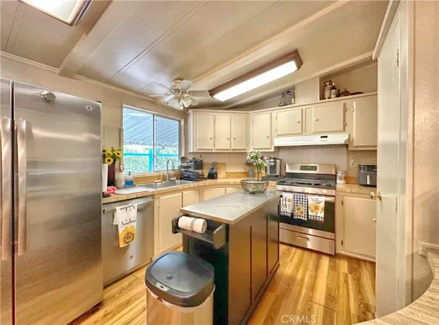 a kitchen with a sink a stove cabinets and stainless steel appliances