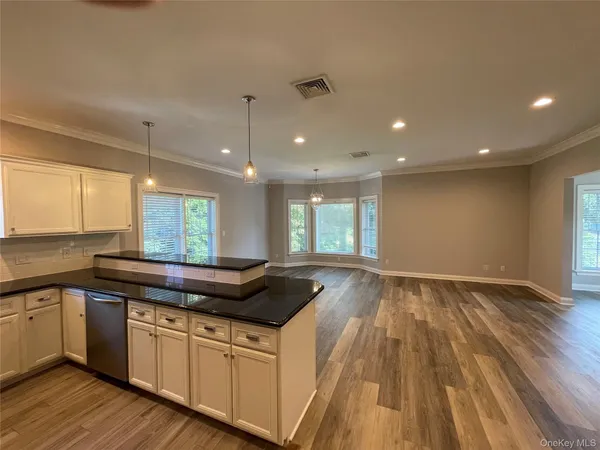 a kitchen with a sink and wooden floor