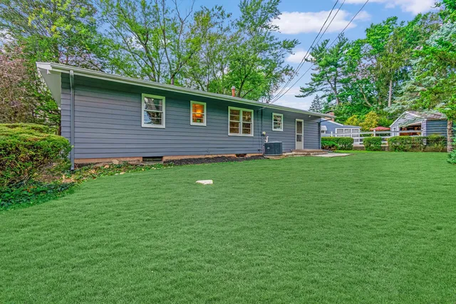 a backyard of a house with table and chairs