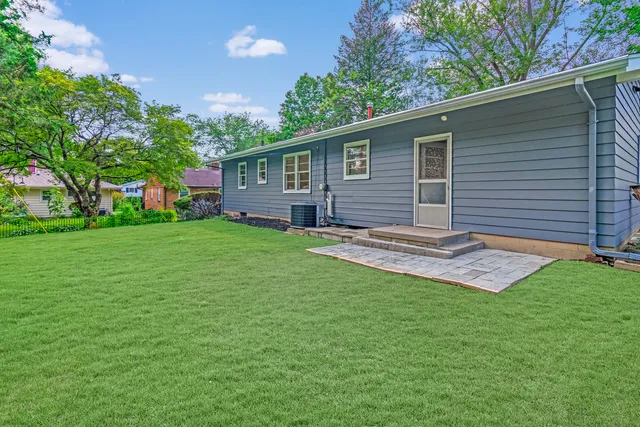 a backyard of a house with table and chairs