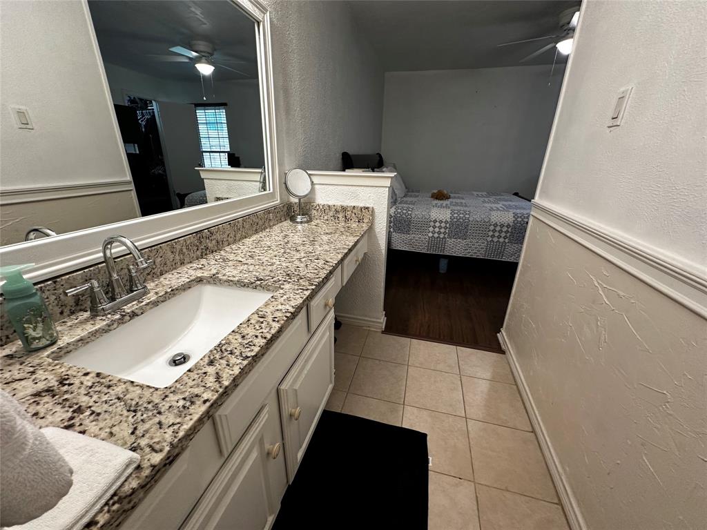 4272 Madera Road, Unit 4 Irving, TX 75038 - Photo 14 of 32 a bathroom with a granite countertop sink a mirror and vanity