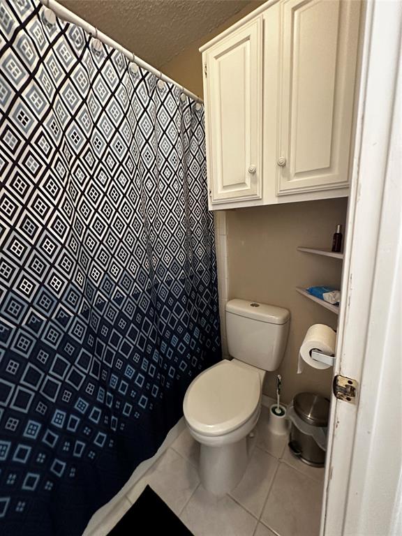 4272 Madera Road, Unit 4 Irving, TX 75038 - Photo 17 of 32 a white toilet sitting next to a shower curtain