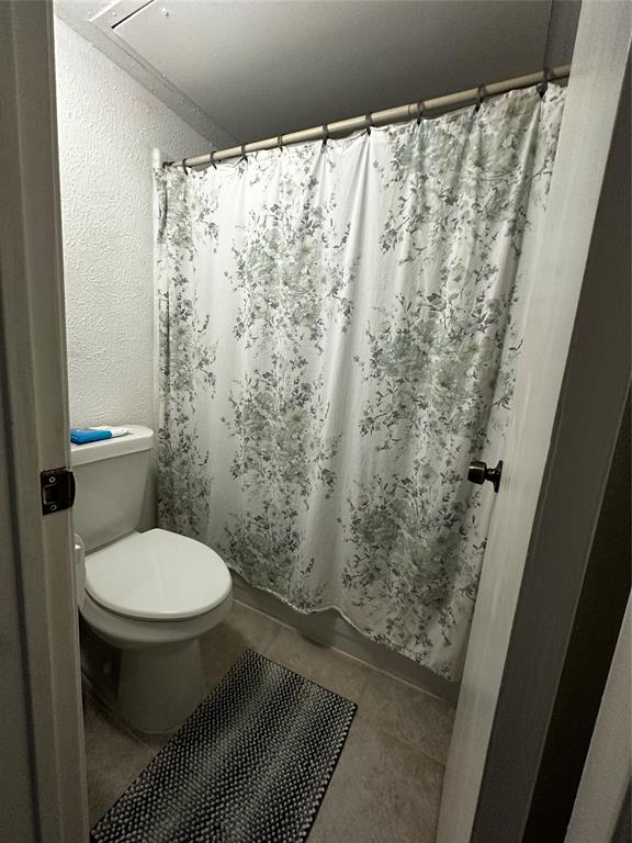 4272 Madera Road, Unit 4 Irving, TX 75038 - Photo 18 of 32 a bathroom with a toilet and a shower curtain