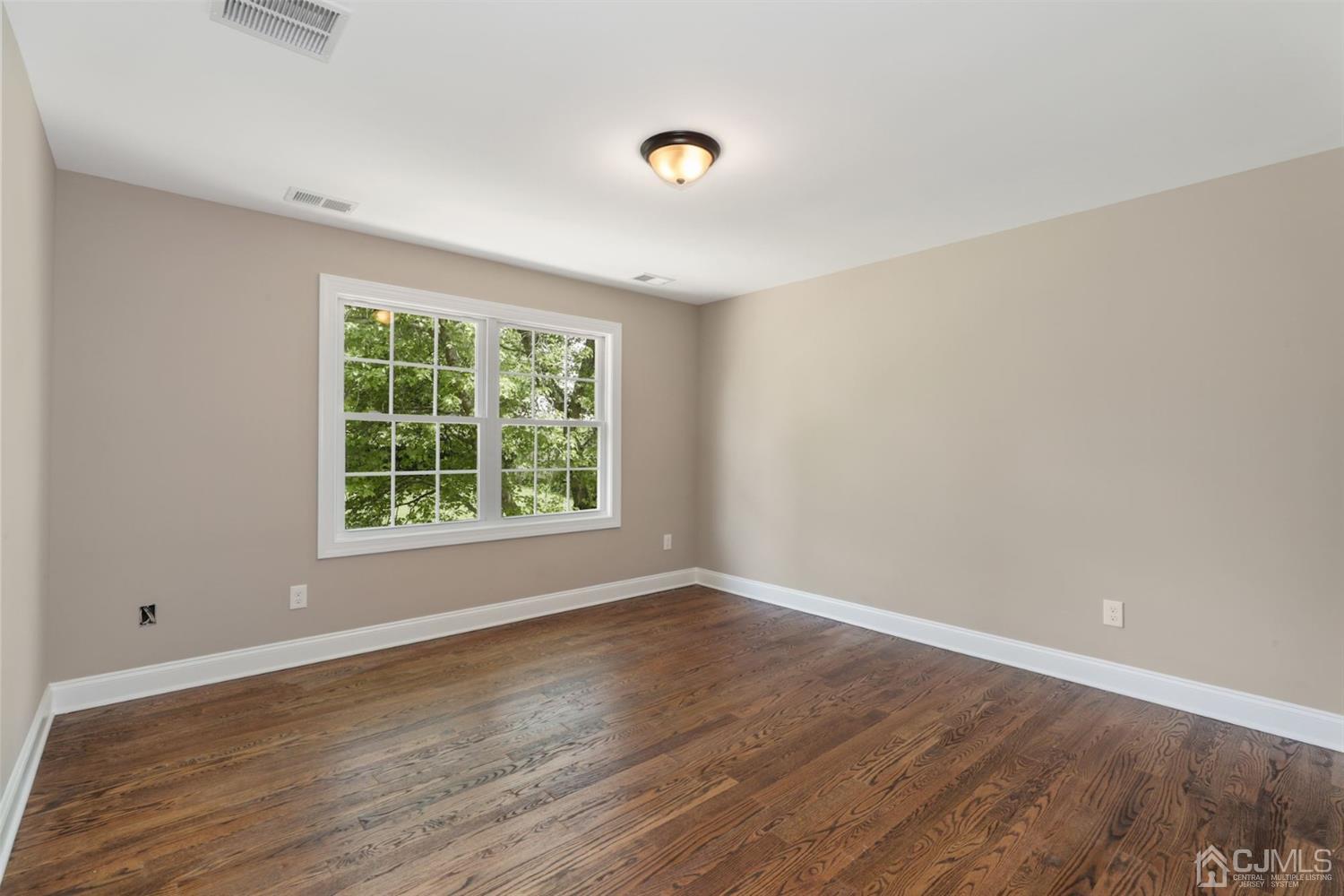 13 Perry Road East Brunswick, NJ 08816 - Photo 15 of 25 wooden floor in an empty room with a window