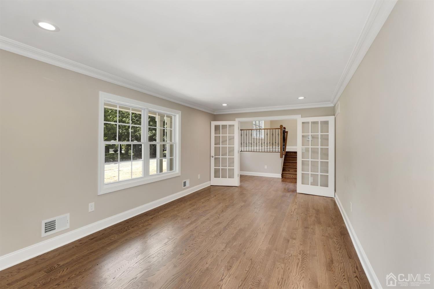 13 Perry Road East Brunswick, NJ 08816 - Photo 4 of 25 an empty room with wooden floor and windows