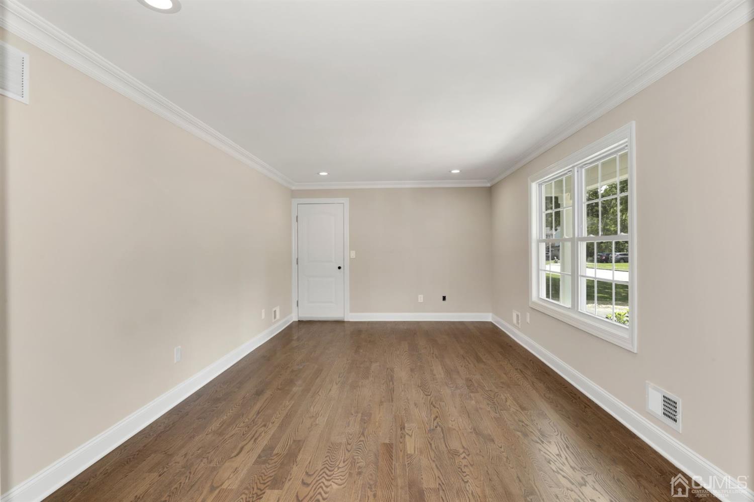 13 Perry Road East Brunswick, NJ 08816 - Photo 5 of 25 an empty room with wooden floor and windows