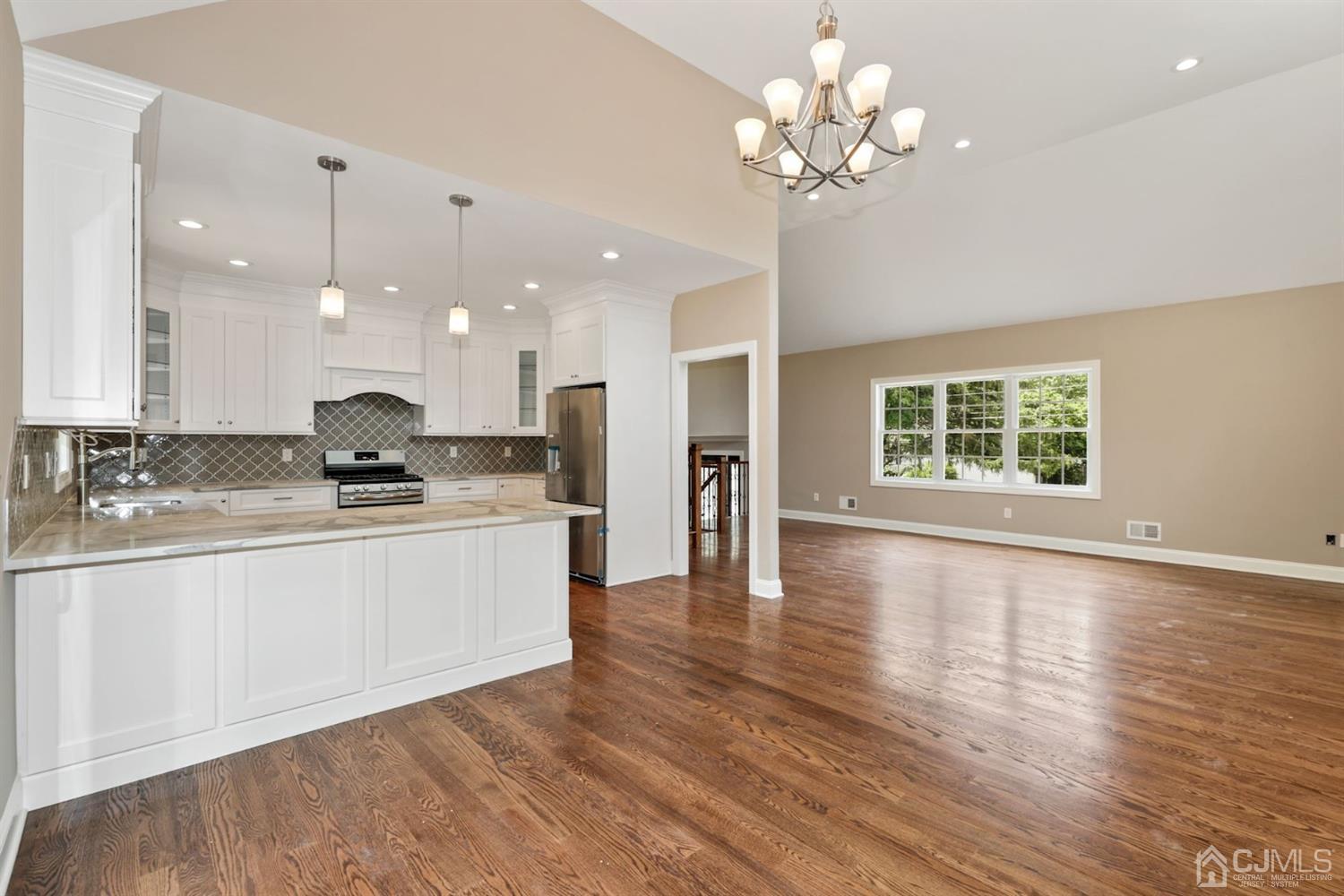 13 Perry Road East Brunswick, NJ 08816 - Photo 7 of 25 a view of a kitchen with granite countertop a stove top oven a sink and a chandelier