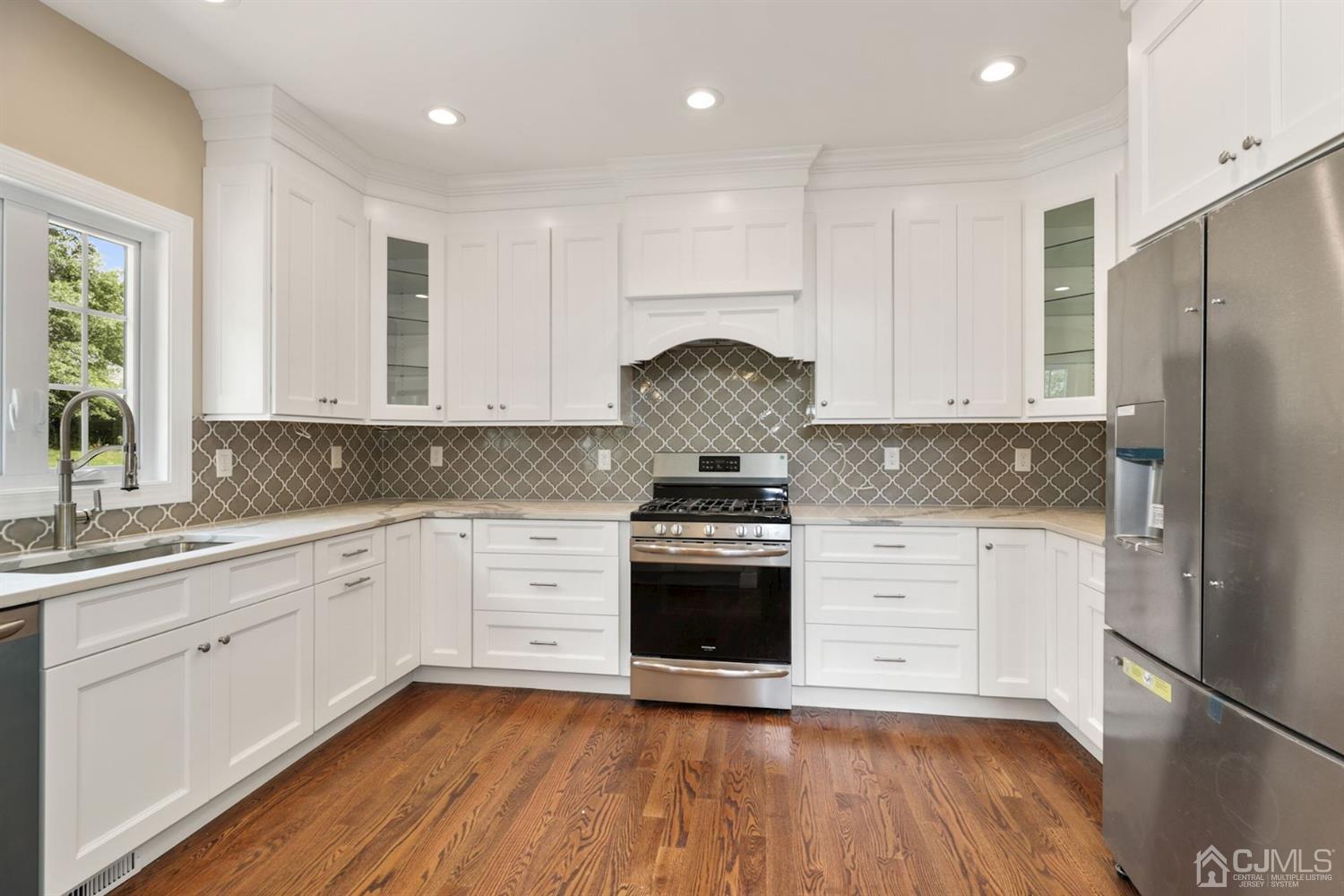13 Perry Road East Brunswick, NJ 08816 - Photo 8 of 25 a kitchen with stainless steel appliances granite countertop a stove a sink and white cabinets