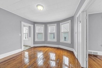 71 Knox Street, Unit 2 Springfield, MA 01105 - Photo 2 of 14 a view of a bedroom with wooden floor and windows