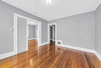 a view of empty room with wooden floor