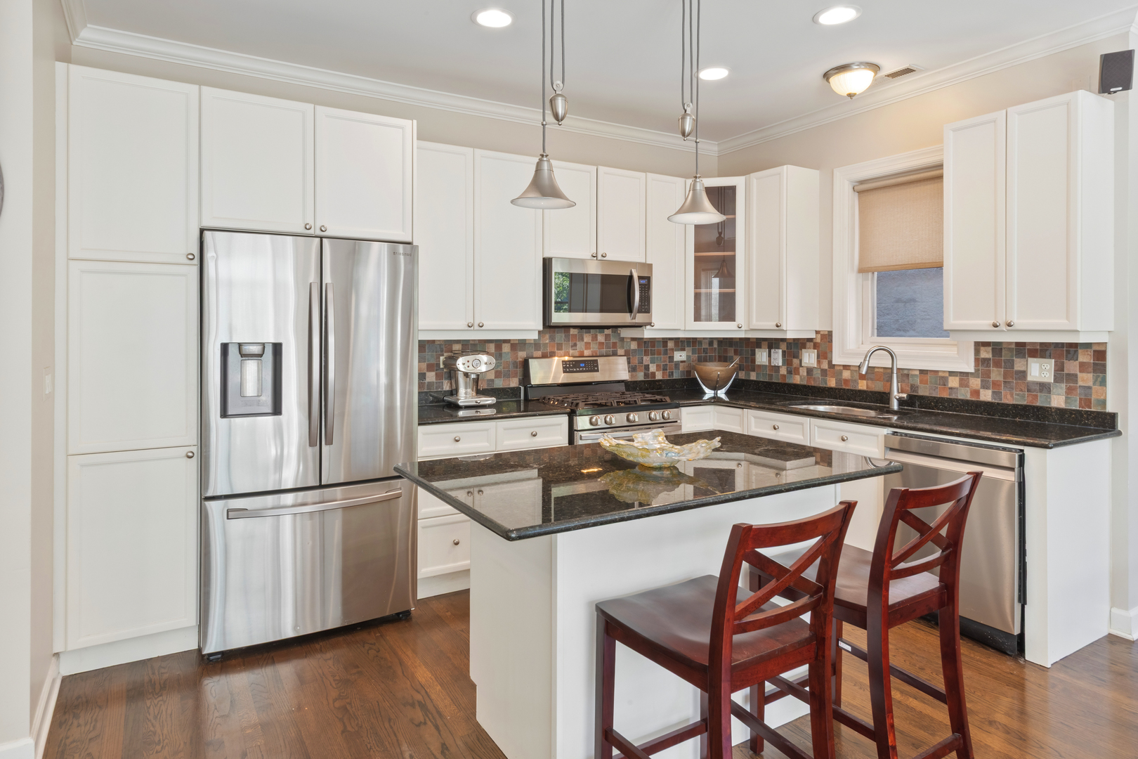 3438 North Ashland Avenue, Unit 2N Chicago, IL 60657 - Photo 11 of 22 a kitchen with stainless steel appliances granite countertop a sink a stove a refrigerator and island with wooden floor