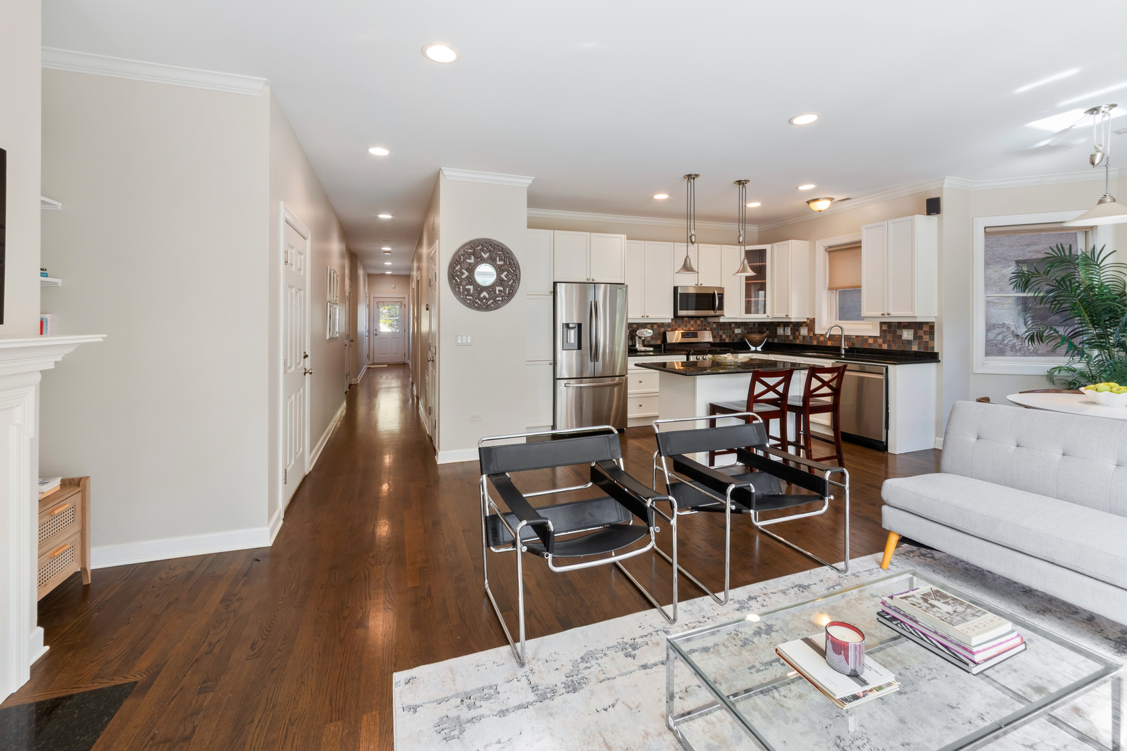 3438 North Ashland Avenue, Unit 2N Chicago, IL 60657 - Photo 7 of 22 a kitchen with stainless steel appliances kitchen island granite countertop a stove a sink a refrigerator and blue cabinets with wooden floor