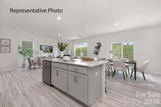a kitchen with lots of wooden furniture dining table and wooden floor