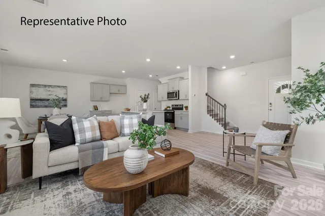 a living room with furniture kitchen and a potted plant