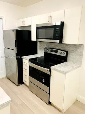 a kitchen with stainless steel appliances a stove microwave and refrigerator