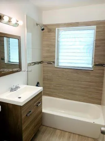 a bathroom with a sink mirror and a bathtub