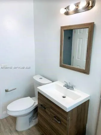 a bathroom with a sink mirror and toilet