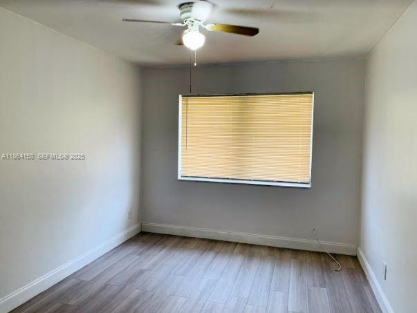 738 Northeast 86th Street, Unit 5 Miami, FL 33138 - Photo 8 of 9 a view of an empty room with wooden floor and a window