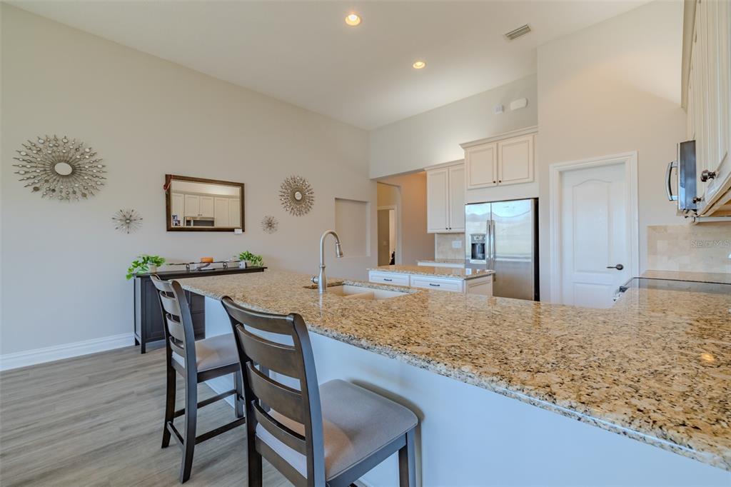 4950 Diamonds Palm Loop Wesley Chapel, FL 33543 - Photo 14 of 65 a view of a kitchen and dining area with wooden floor