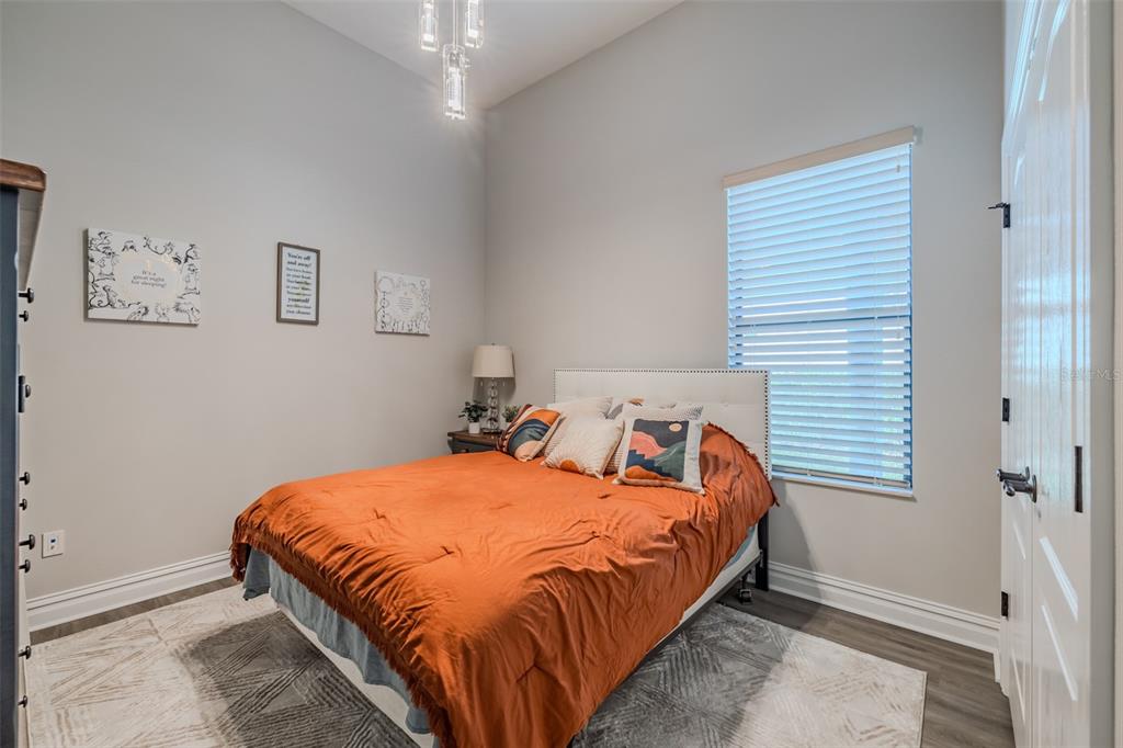 4950 Diamonds Palm Loop Wesley Chapel, FL 33543 - Photo 30 of 65 a bedroom with a bed and a lamp