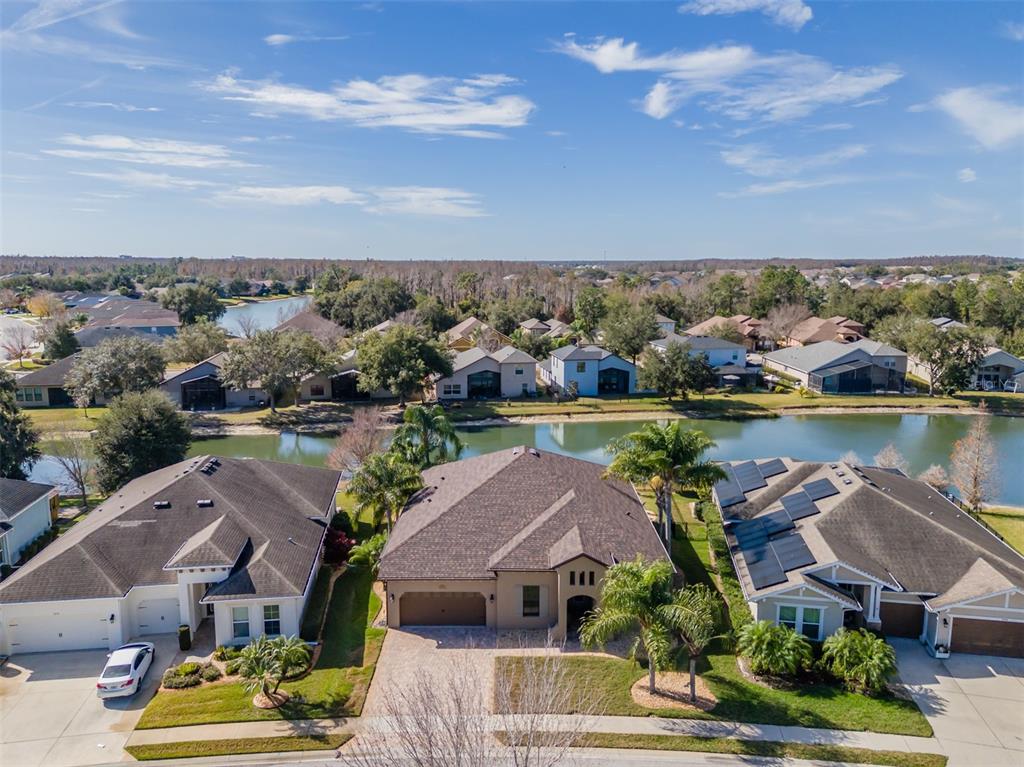 4950 Diamonds Palm Loop Wesley Chapel, FL 33543 - Photo 40 of 65 an aerial view of a residential houses with outdoor space and lake view in back