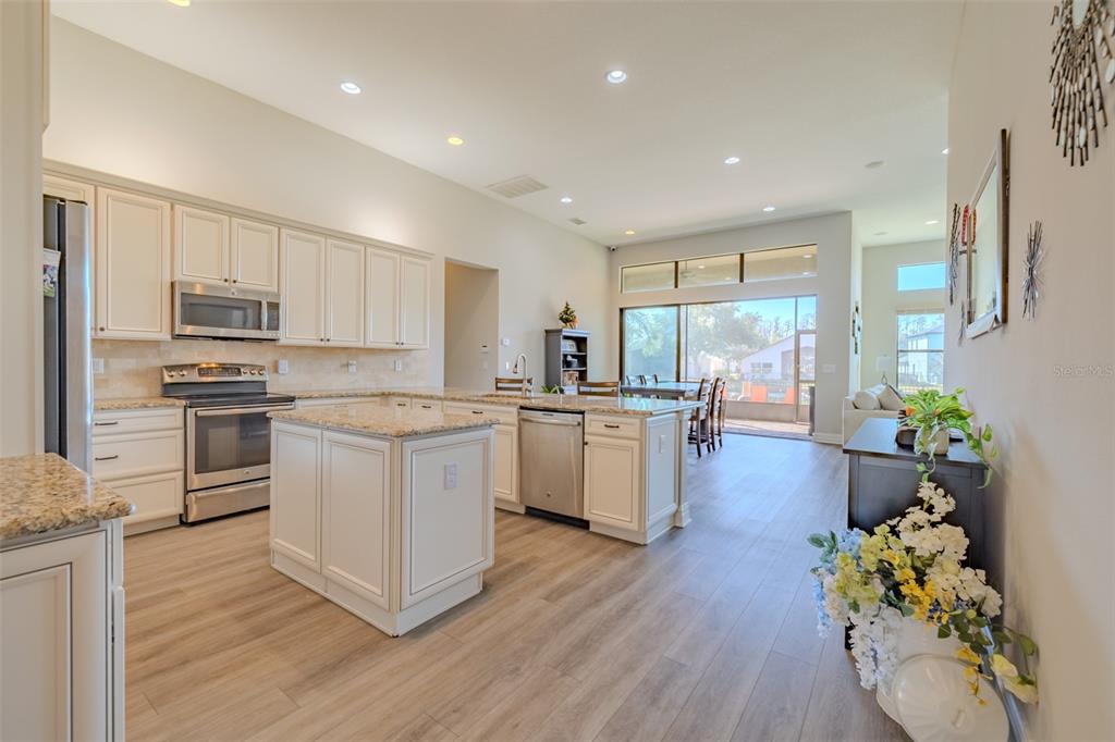 4950 Diamonds Palm Loop Wesley Chapel, FL 33543 - Photo 7 of 65 a kitchen with white cabinets and appliances