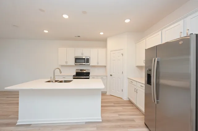 a kitchen with a sink a counter top space stainless steel appliances and cabinets