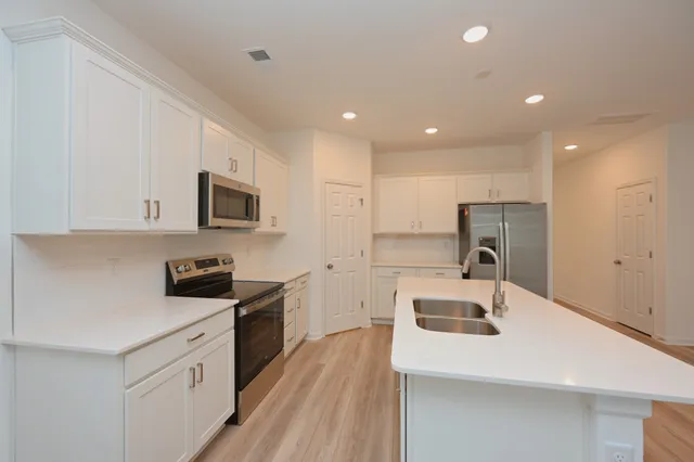 a view of kitchen with wooden floor and electronic appliances