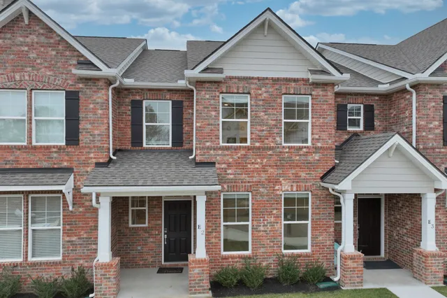 a front view of a house with a yard and outdoor seating