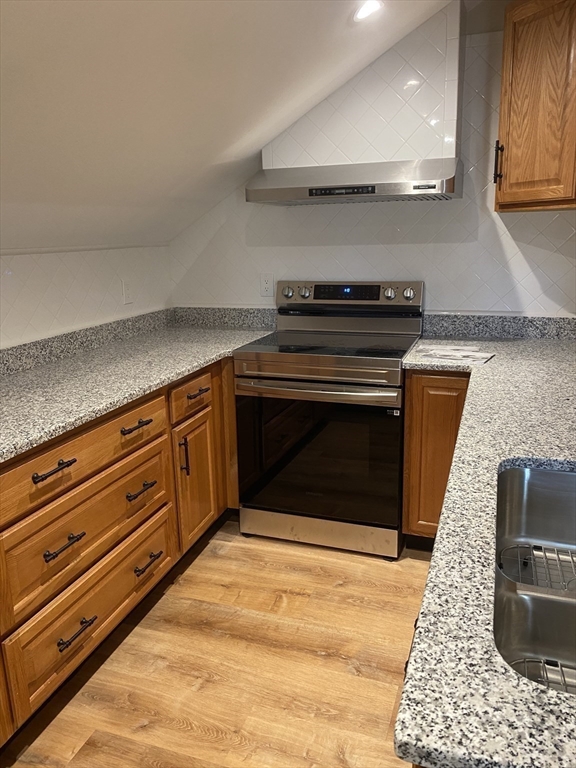 374 Main Street, Unit 2 Gloucester, MA 01930 - Photo 5 of 12 a kitchen with granite countertop a stove and a wooden floors