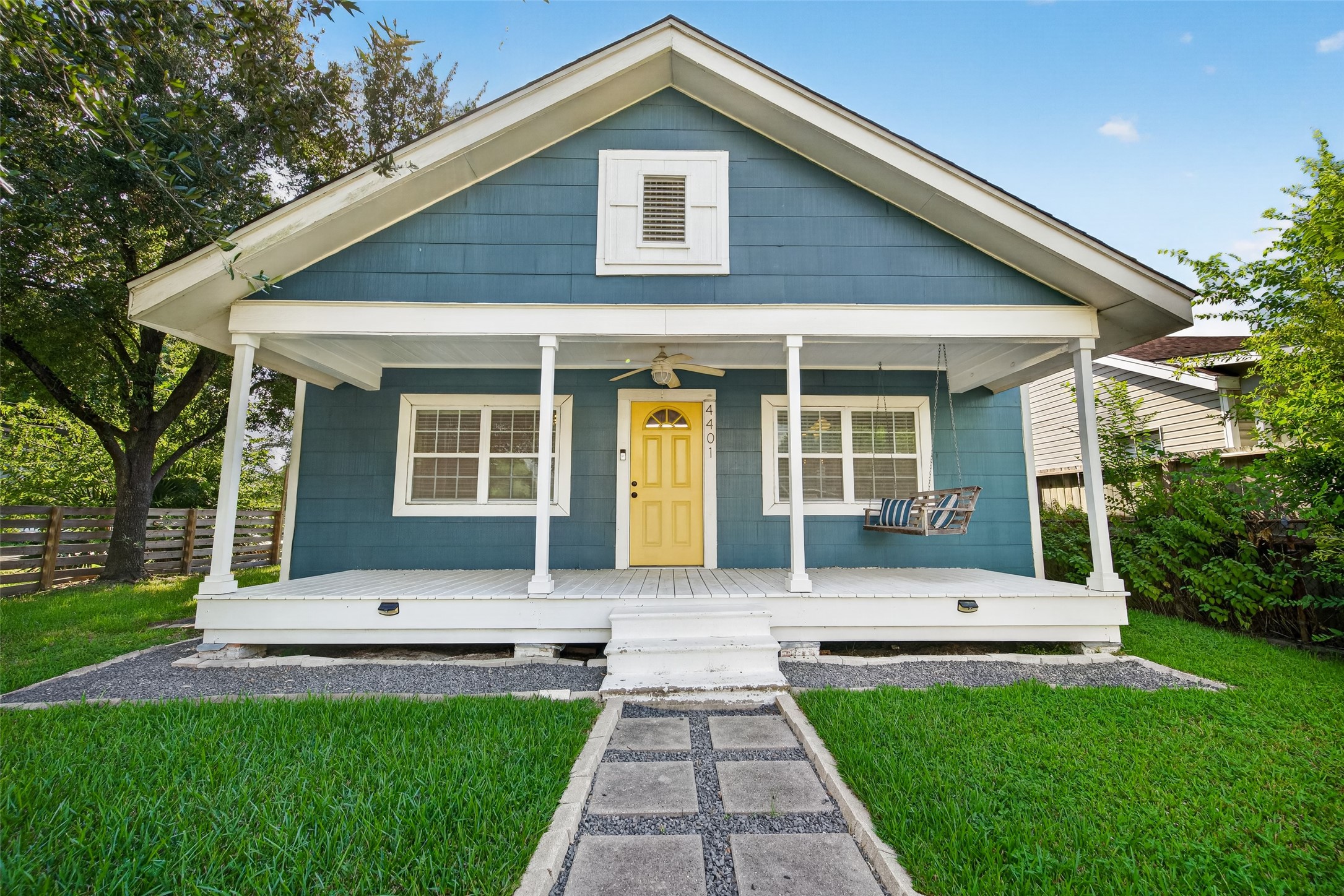 4401 Hain Street Houston, TX 77009 - Photo 1 of 22 Deep teal siding, a yellow front door, and a full-width covered porch give this 1945 bungalow distinctive curb appeal, framed by a mature shade tree and fenced corner lot.